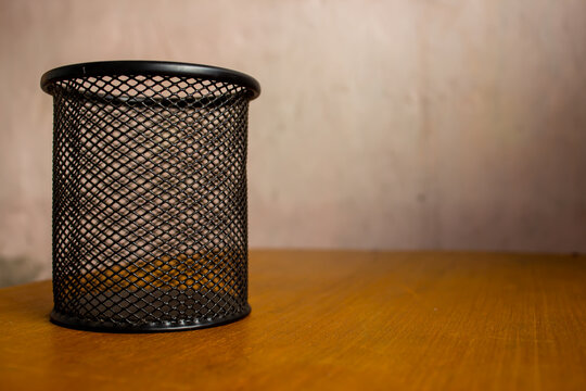 Black Metal Mesh Pencil Holder on Wooden Desk with Copy Space