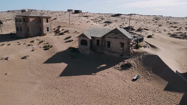 Abandoned ghost town of kolmanskop in the namib desert reclaimed by nature and sand dunes an aerial view