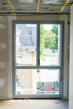 Espace en r&eacute;novation montrant des travaux sur les fen&ecirc;tres, les murs et la toiture, illustrant un chantier de transformation et de restauration d&rsquo;un b&acirc;timent.
