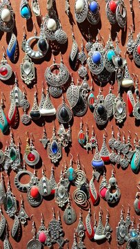 Pr&eacute;sentoir de bijoux, pendants d'oreilles marocains traditionnels en argent et pierres pr&eacute;cieuses expos&eacute; dans un souk