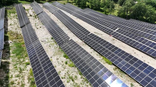 A beautiful aerial drone shot of a small-scale, localized solar farm situated within a rural landscape
