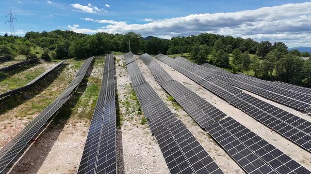 A beautiful aerial drone shot of a small-scale, localized solar farm situated within a rural landscape