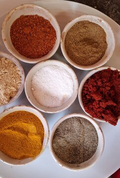 Ensemble de petits bols contenant des &eacute;pices : sel, paprika, cumin, poivre noir, gingembre, curcuma pour la r&eacute;alisation de sp&eacute;cialit&eacute;s culinaires marocaines, m&eacute;diterran&eacute;ennes