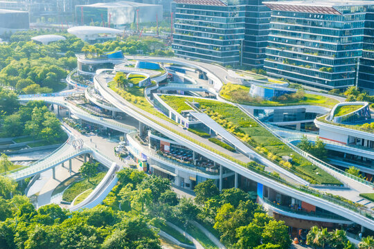 Shenzhen innovative mixed use complex with green rooftop terraces and futuristic architecture surrounded by urban parkland. Sustainable city development and smart design, Guangdong Province, China