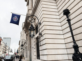 Naklejka premium Historic London street with ornate lanterns and grand stone Royal Automobile Club building facade in London, UK