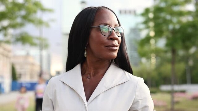 Elegant woman wearing glasses smiling in the city center
