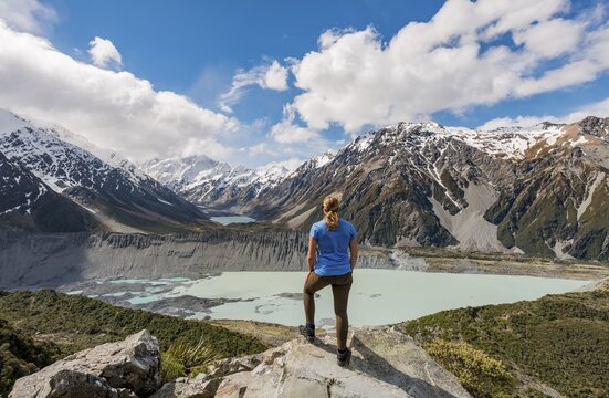 Hiker standing on rocks, view into the Hooker Valley from Sealy Tarns Track, glacial lakes Mueller Lake and Hooker Lake, Mount Cook National Park, Canterbury Region, South Island, New Zealand