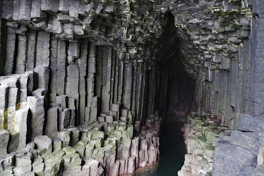 Dark cave with impressive basalt columns and deep water in a natural setting, Staffa, Inner Hebrides, Scotland, United Kingdom