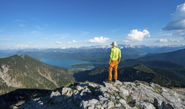 Hiker at the summit of Heimgarten, view into the distance, Karwendel Mountains in the background, ridge walk Herzogstand Heimgarten, Upper Bavaria, Bavaria, Germany