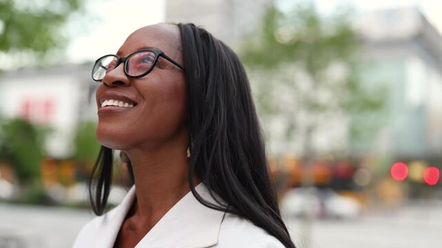 Elegant woman wearing glasses smiling in the city center
