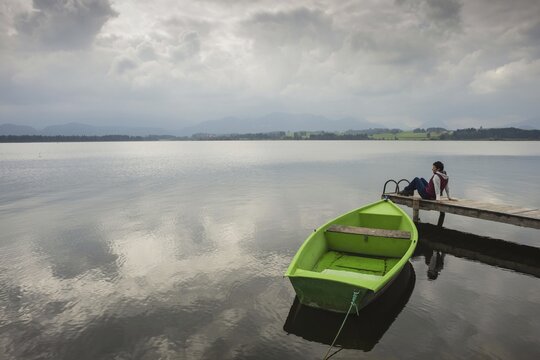 Woman 50-60, wooden jetty, green rowing boat, Hopfensee, Hopfen am See, near F&uuml;ssen, Ostallg&auml;u, Allg&auml;u, Bavaria, Germany