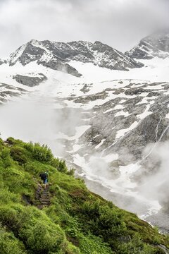 Mountaineers on a hiking trail, in the background glaciated peak Dosso Largo and glacier Schlegeiskees, cloudy atmospheric mountain landscape, ascent to Furtschaglhaus, Berliner H&ouml;henweg, Zillertal, Tyrol, Austria