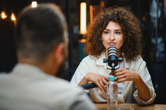 Two content creators recording podcast in modern studio