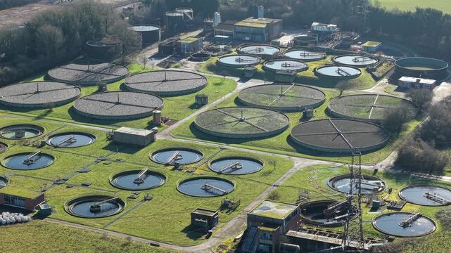 Drone shot flying over an urban sanitation facility with industrial anaerobic digesters near Luton UK