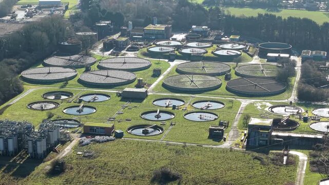Overhead view of a public utility water recycling center showing rows of circular filtration settlement tanks