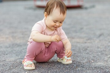 Fototapeta premium Toddler playing with gravel and exploring textures through sensory play