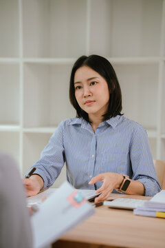 HR manager interviewing a job candidate across a desk, discussing qualifications and experience during a recruitment meeting in a modern office environment.
