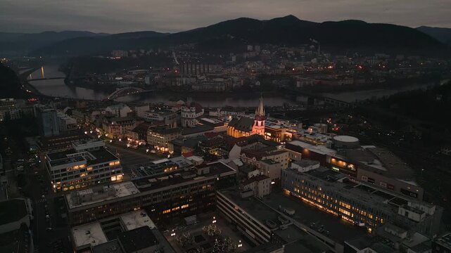 Aerial drone night view of &Uacute;st&iacute; nad Labem, showcasing the illuminated Church of the Assumption, M&iacute;rov&eacute; n&aacute;měst&iacute; square, and illuminated bridges spanning the Labe River under a dark sky