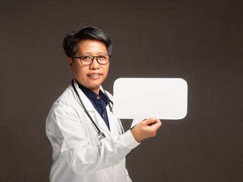 Female doctor holding blank speech bubble sign