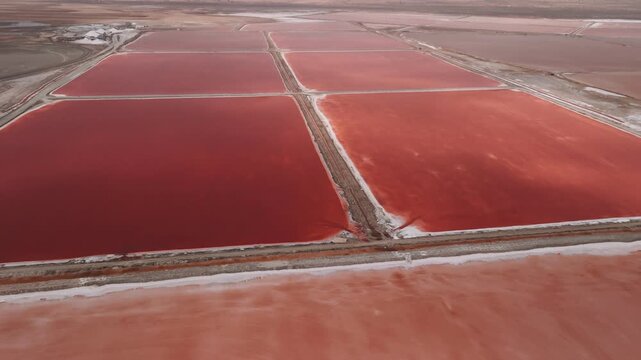 Aerial view of red salt pans in walvis bay, namibia, showcasing the unique pink water from algae in the evaporation ponds