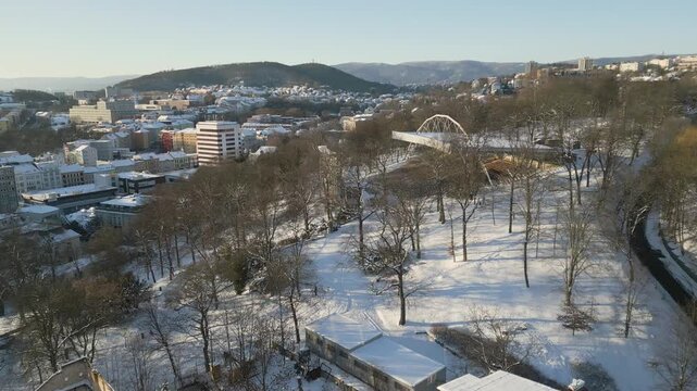 An elevated drone winter view of the open-air summer cinema in &Uacute;st&iacute; nad Labem shows rows of empty, snow-covered amphitheater seating and a large projection screen under a massive metal roof structure 