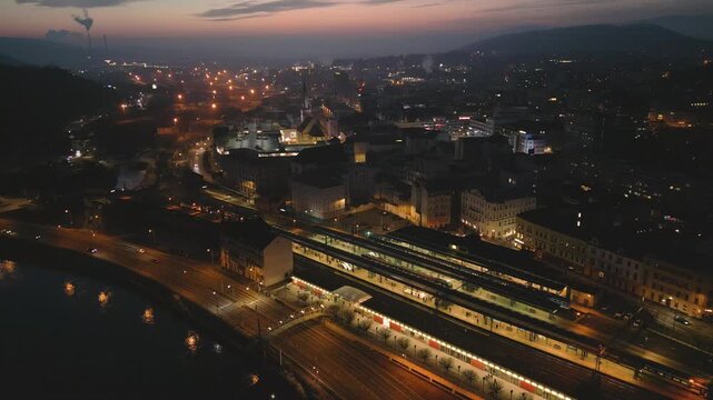 Aerial night view of &Uacute;st&iacute; nad Labem, showcasing the illuminated Church of the Assumption, M&iacute;rov&eacute; n&aacute;měst&iacute; square, and illuminated bridges spanning the Labe River under a dark sky.