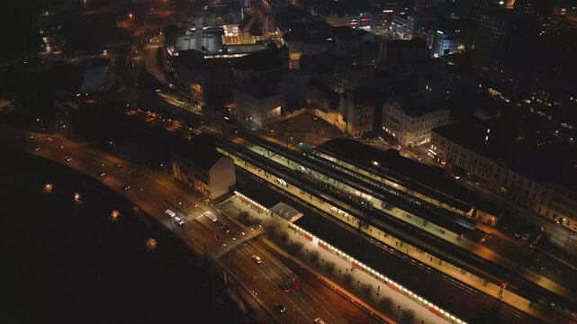 Aerial night view of &Uacute;st&iacute; nad Labem, showcasing the illuminated Church of the Assumption, M&iacute;rov&eacute; n&aacute;měst&iacute; square, and illuminated bridges spanning the Labe River under a dark sky.