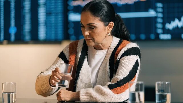 Medium shot of a family office executive analyzing customized investment policy statements with digital graphs and data softly out of focus behind.
