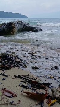 Cinematic slow-motion waves crashing against rocks on the sandy shores of Radhanagar Beach, Andaman Islands.