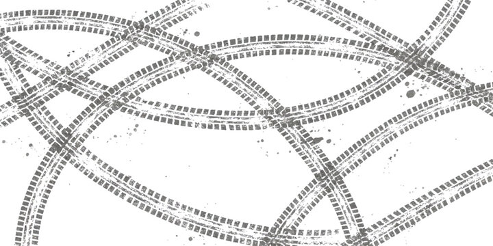 Black tire tracks forming circular patterns on a flat surface