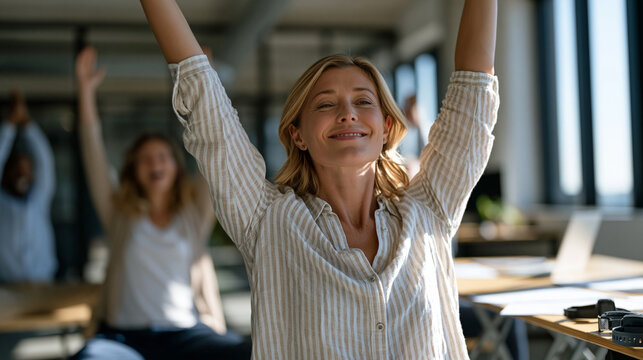 Midsize company wellness program coordinator guiding employees through seated stretching during a lunch break in a sunlit open office, participation forms and fitness trackers
