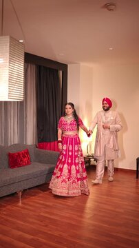 Vertical Shot of Indian Bride and Groom Walking While Holding Hands