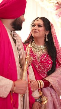 Vertical Shot of Indian Bride and Groom Looking at Each Other and Smiling
