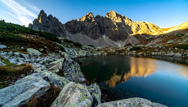 Breathtaking mountain lake reflecting golden sunset peaks, evoking a sense of wanderlust and serenity
