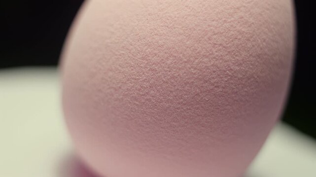50p extreme close up macro shot of a pink makeup sponge rotating to reveal texture