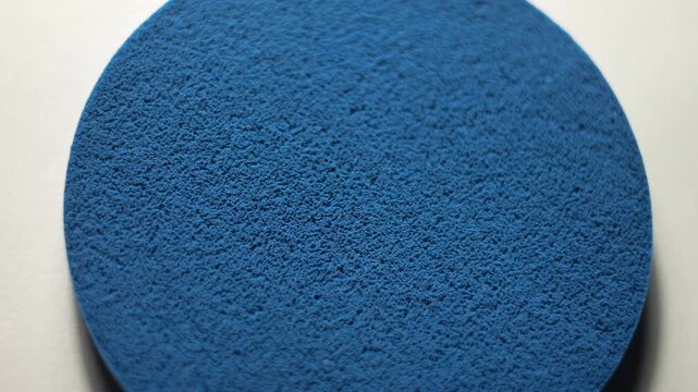 50p extreme close up macro shot of a blue makeup sponge rotating to reveal texture