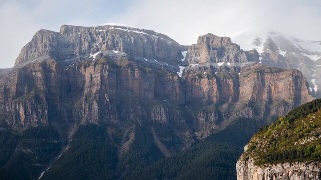 Timelapse of moving clouds and changing light over a majestic mountain range in the pyrenees