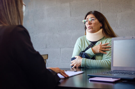Injured senior woman explaining accident details to personal injury attorney