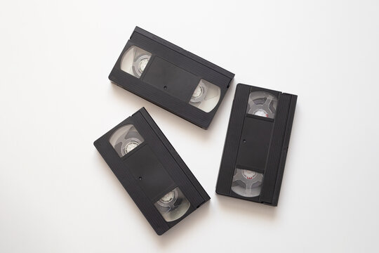 Old video tape on white background triggers nostalgia for nineties childhood, video tape memories of recording favorite shows and movies, nostalgia captured in black plastic cassette with retro label.