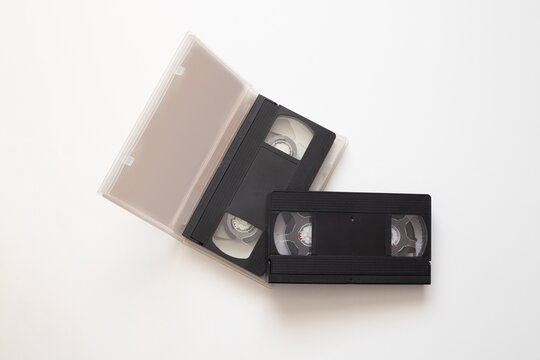 Precious memories stored on old video tape with magnetic reels, video tape memories of birthdays and holidays now frozen in time, memories preserved in black plastic case on white background.