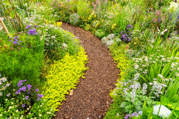 Naklejka premium flowers with path leading through a flower garden