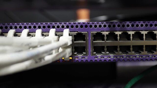 Close-up of network switch ports with connected cables and blinking lights