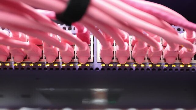 Connecting network cables to a server rack with blinking lights