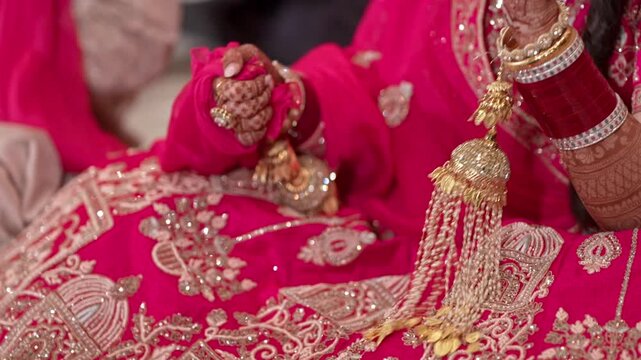 Closeup of an Indian Bride in Pink Lehenga Adjusting her Traditional Wedding Kewelry and Chooda