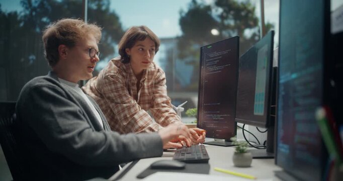 Young Female Engineer Collaborate With Male UX Designer in Modern Office, Coding on Stacked Monitors to Refine AI Ecommerce App Checkout, Mobile UI, API Permissions, Security Before QA Release.