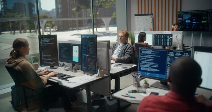  Using Working Computer. Software Team Builds a Fintech Mobile App in Office: Female Coder Types Backend Scripts, Male Engineer Debugs UI, and Developer Audits Cybersecurity Code on Screens.