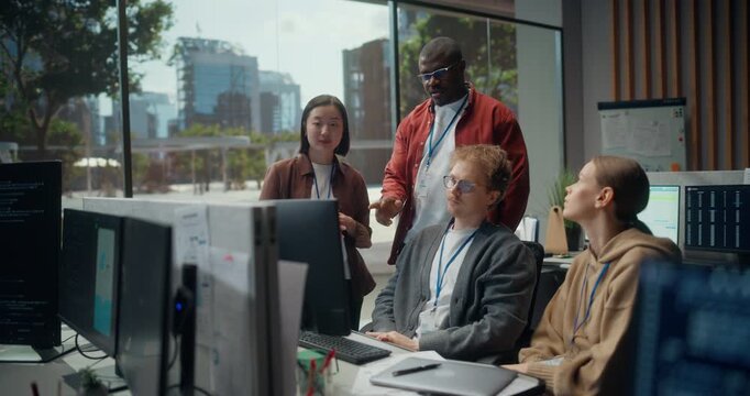 Four person Software Dev Team Meeting Writing  Code. Female Engineer Points at Display While Black Male Lead and Asian Woman Developer Analyse App Cybersecurity, AI Algorithm and UI  Office.