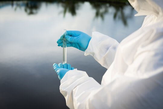 Environmental researchers in protective suit collect water samples in farmland for research and development .