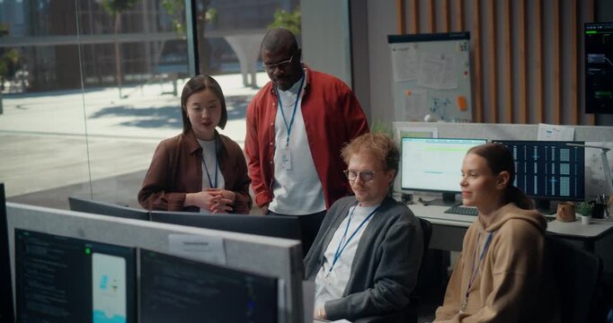 Young Dev Team Gather Meeting Discuss Code on Displays in a Modern Office: White Male Programmer Explains App to a Seated Woman as Black and Asian Engineers Join, Using AI, Cybersecurity.