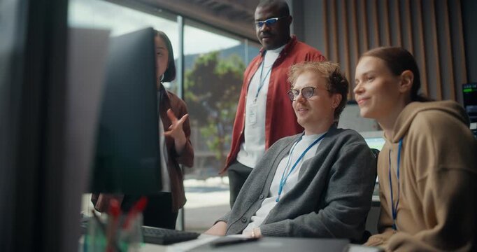 Young Dev Team Gather Meeting Discuss Code on Displays in a Modern Office: White Male Programmer Explains App to a Seated Woman as Black and Asian Engineers Join, Using AI, Cybersecurity.